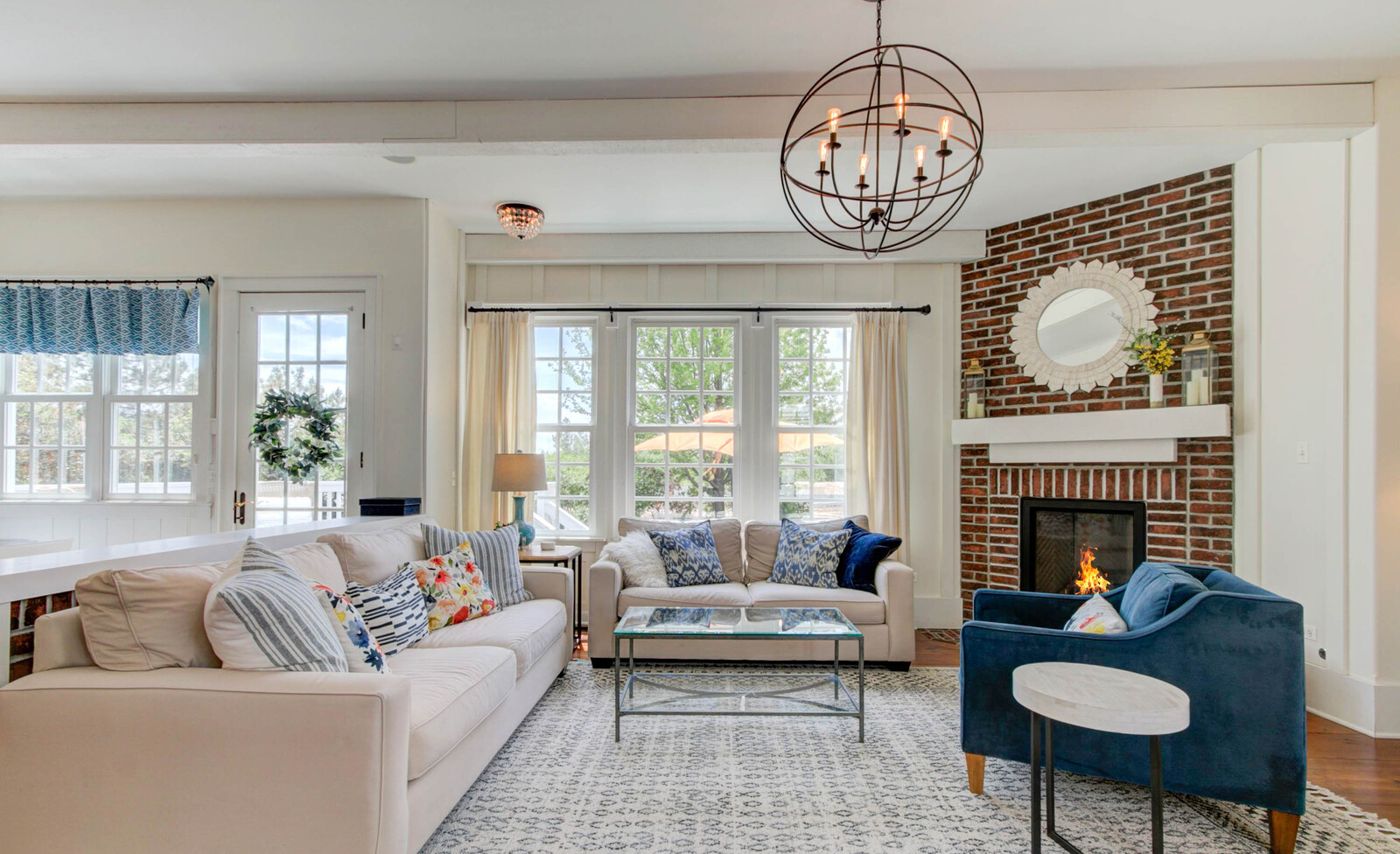 Living room with fireplace and blue accent chairs, professionally photographed
